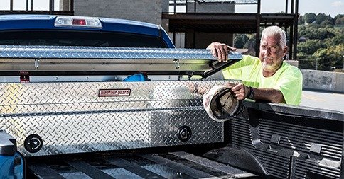 worker putting final touches on truck trunk box