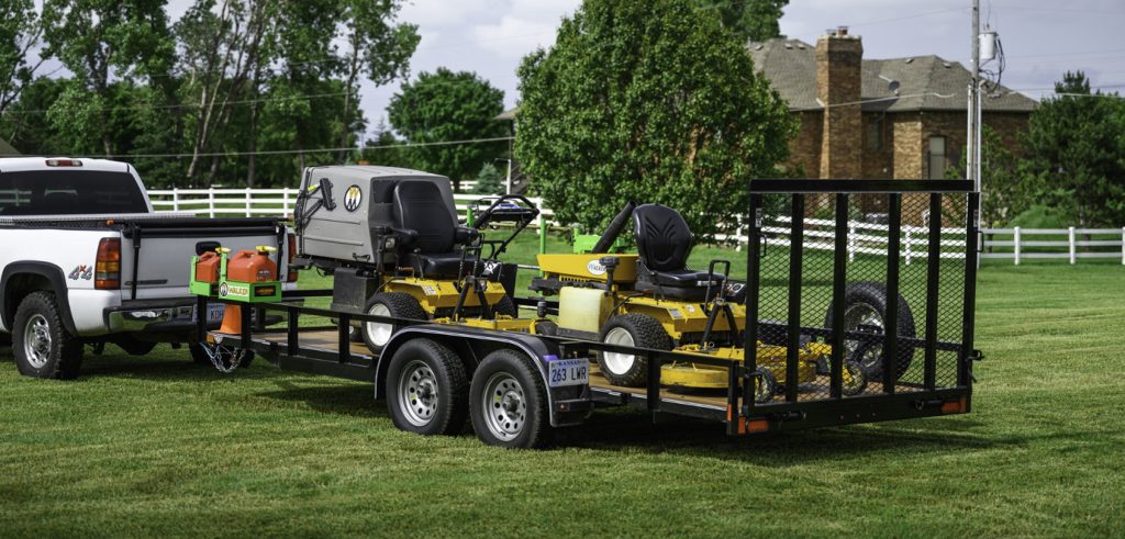 Truck with commercial vehicle trailer holding several lawnmowers